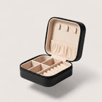 Magillas portable black travel jewelry case with champagne plush interior, ring rolls, and necklace hooks.
