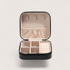 Magillas portable black travel jewelry case with champagne plush interior, necklace hooks, and ring storage compartments.