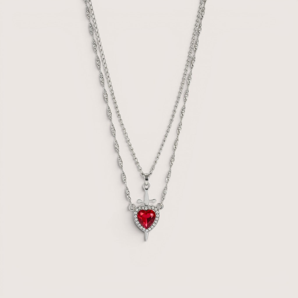 Collar doble de acero inoxidable y zamak con colgante de corazón rojo y espada, de Magillas.