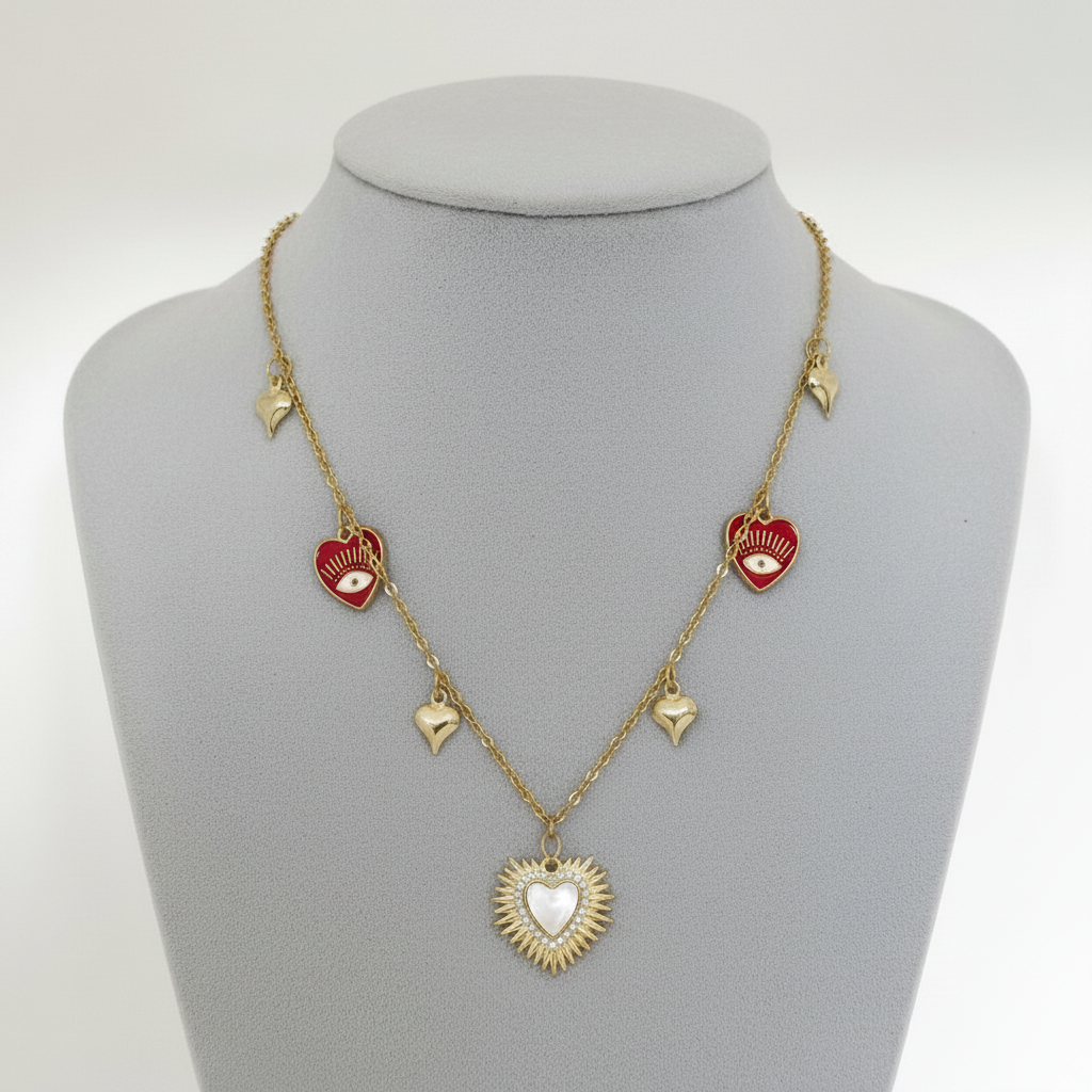 Collar Magillas dorado con dijes de corazones rojos, ojos turcos y un colgante central de corazón estilo sol.