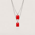 Magillas collar de pareja con dos colgantes rojos en forma de pieza de Lego, elaborados en pasta y acero inoxidable.