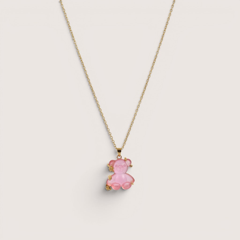 Collar de Magillas con colgante de oso rosa translúcido y detalles dorados.