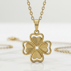 Collar Magillas con colgante de trébol de cuatro hojas en tono dorado brillante sobre fondo de mármol blanco