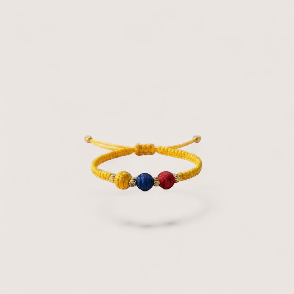 Magillas yellow braided bracelet with red, blue, and yellow beads, inspired by Colombian flag colors.