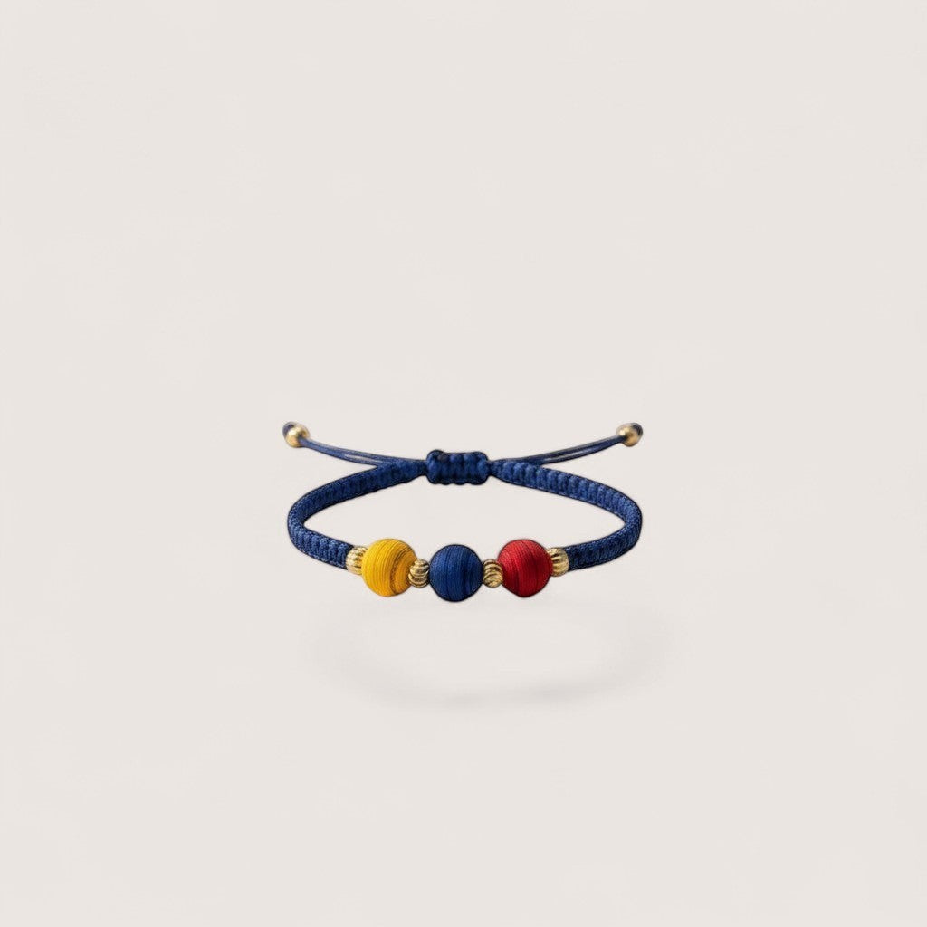 Magillas blue braided bracelet with red, blue, and yellow beads and gold accents. Adjustable.