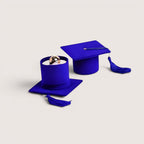 Estuche para anillos con forma de birrete de graduación azul de Magillas, con borla morada.