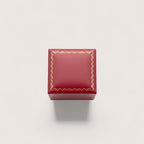 Estuche de joyería rojo burdeos de Magilla con borde dorado y detalles ornamentales.