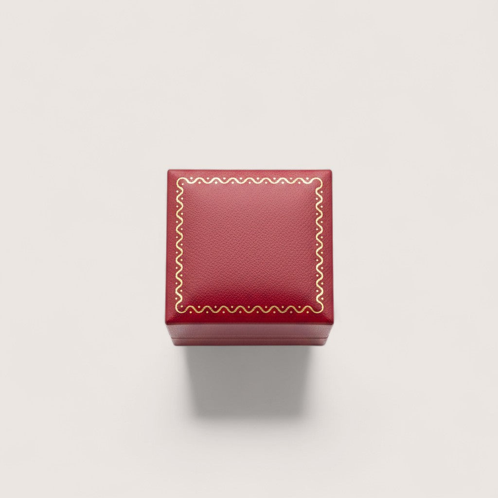 Estuche de joyería rojo burdeos de Magilla con borde dorado y detalles ornamentales.