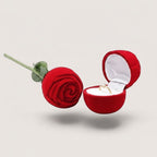 Estuche para anillos en forma de rosa roja de terciopelo, con un anillo de oro y diamante dentro.