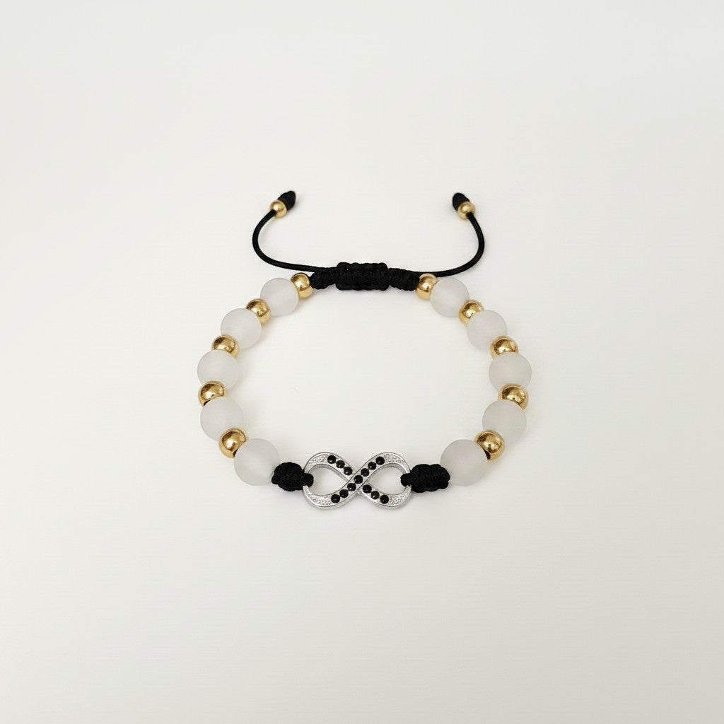 Magillas black beaded bracelet with gold infinity symbol and black rhinestones. Adjustable cord.