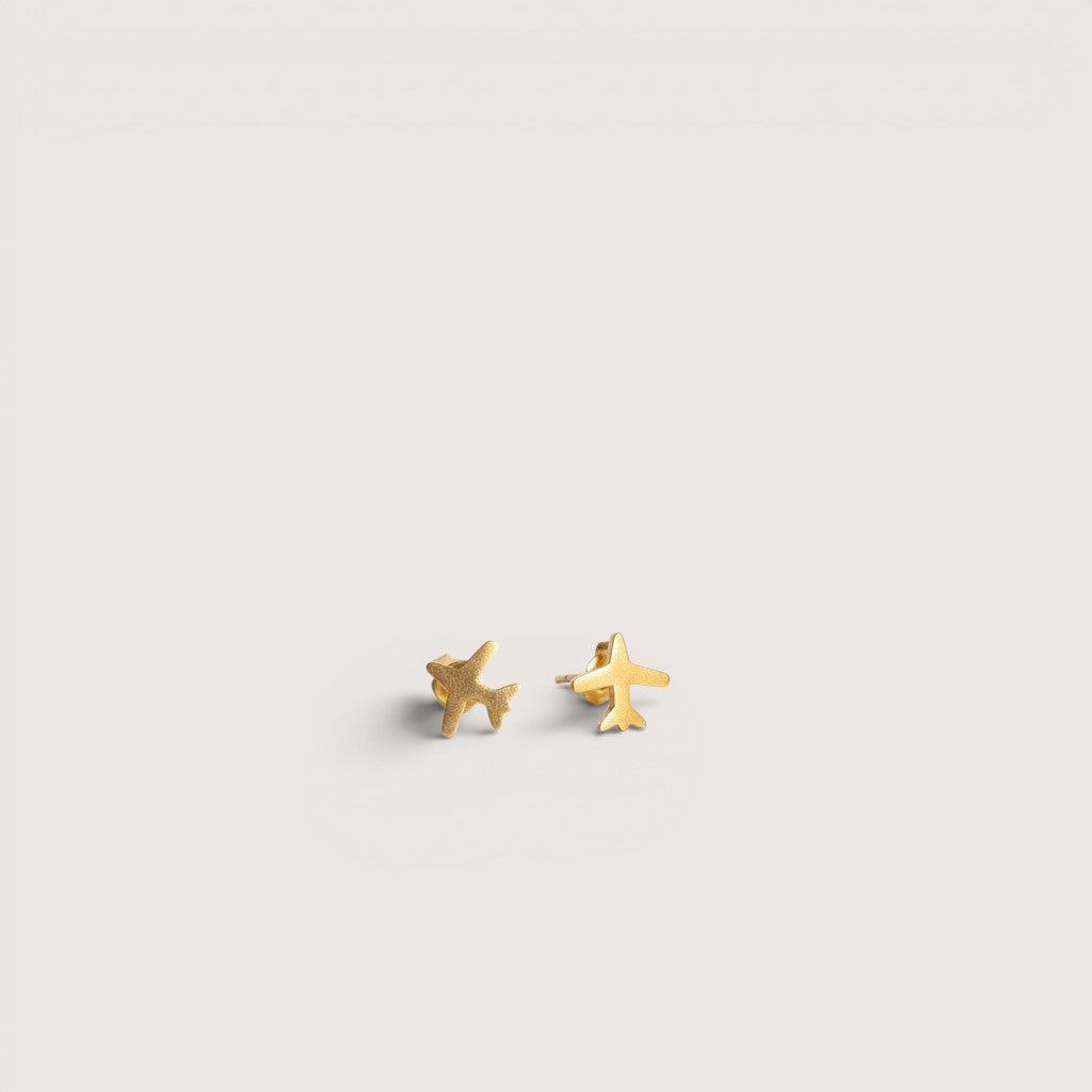 Magillas pendientes dorados con forma de avión, elaborados en acero inoxidable.