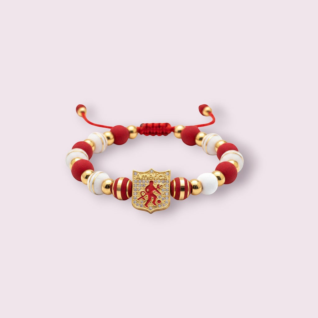 Pulsera Magillas de acero inoxidable, neopreno y rodio con cuentas rojas, blancas y doradas y un escudo con un futbolista.