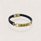 Pulsera esclava de cuero trenzado negro con placa personalizable de acero inoxidable dorado de Magillas.