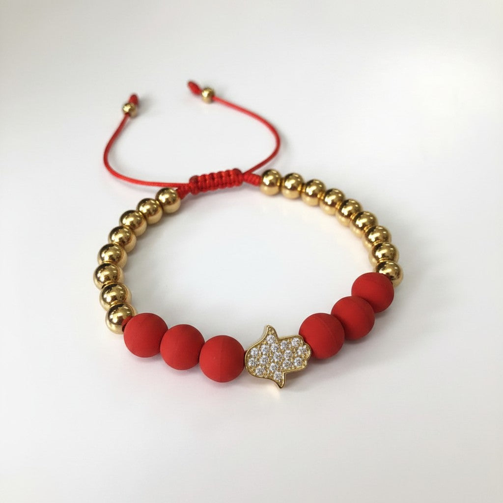 Pulsera Magillas de acero inoxidable, neopreno y rodio con cuentas doradas, rojas y amuleto de mano de Fátima con circonitas.