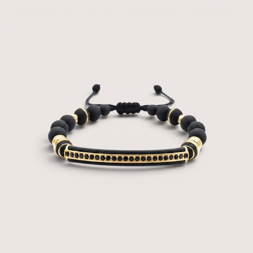 Pulsera Magillas de neopreno y acero inoxidable con detalles dorados y circonitas negras.