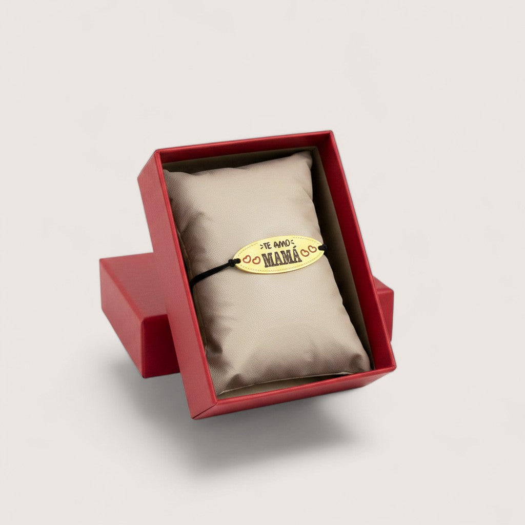 Pulsera Magillas "Te Amo Mamá" con dije ovalado dorado y cordón negro ajustable. Ideal para regalo.