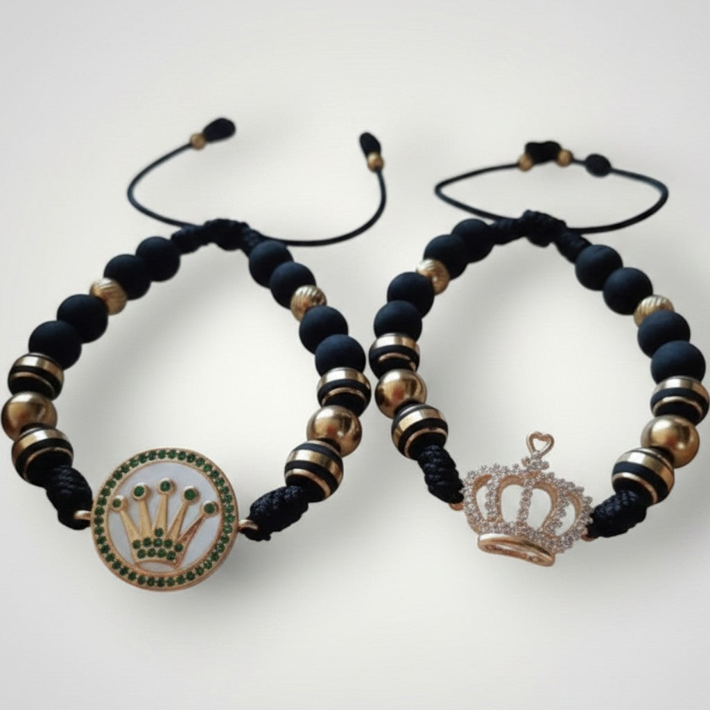 Magillas pulseras de acero inoxidable y neopreno negras con detalles dorados y dijes de corona, se venden en par.