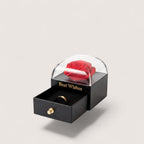 Magillas decorative jewelry gift box with a red preserved rose, clear dome, and pull-out drawer holding a gold ring.